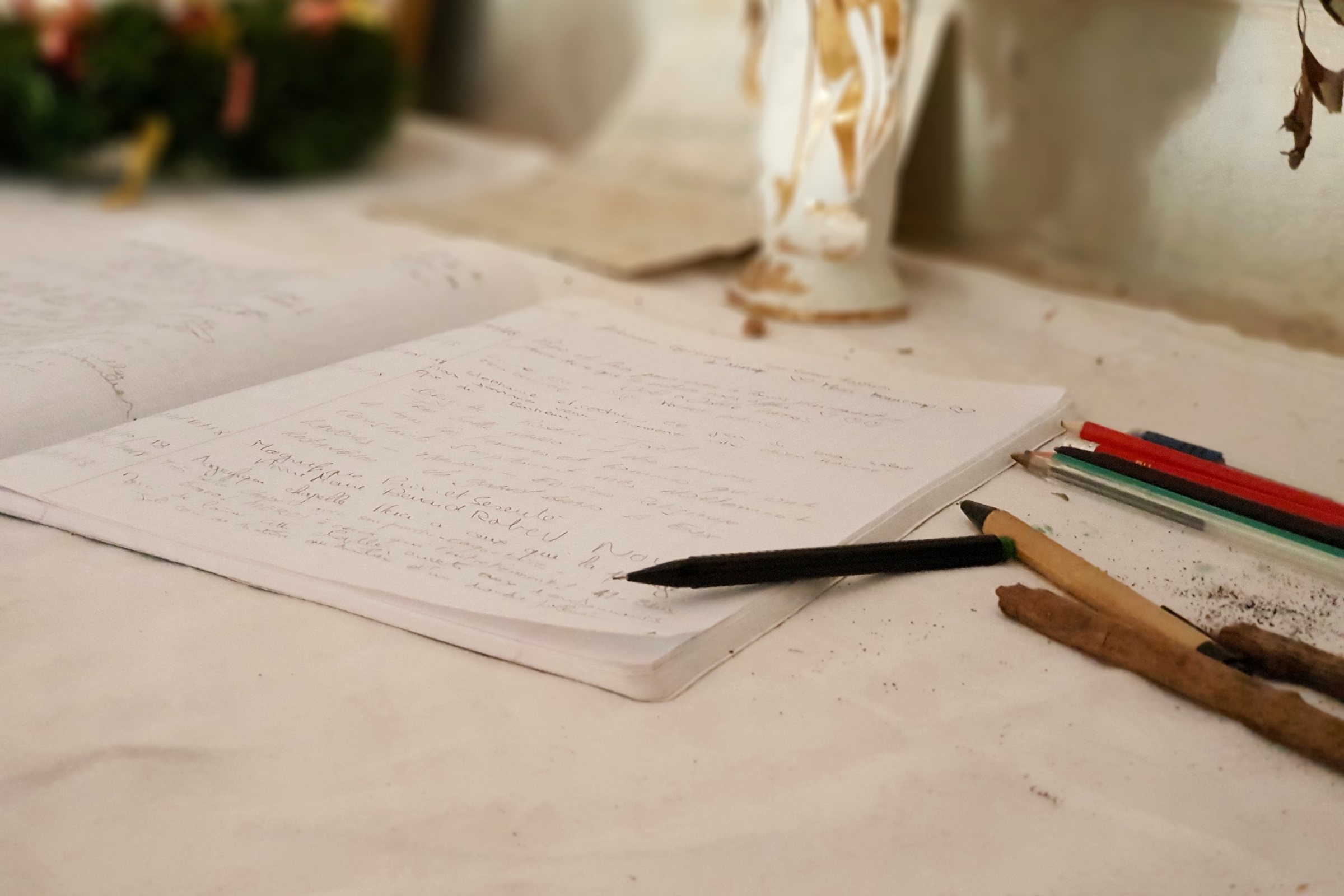 The visitors&rsquo; book and pencils on the altar cloth of the Chapelle Saint-Saturnin, a Romanesque chapel in the woods near Saint-Cézaire